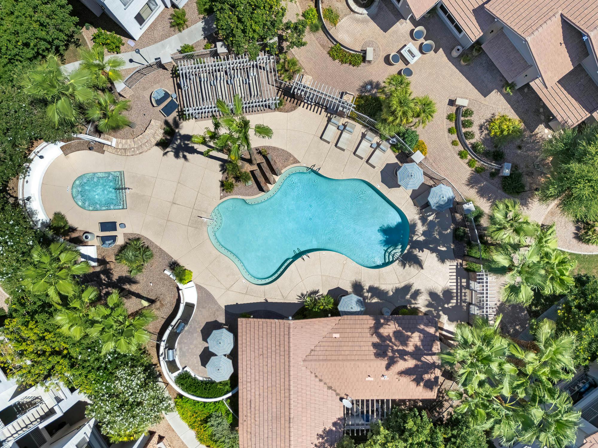 Drone view of resort-style apartment swimming pool and outdoor amenities in Gilbert, AZ