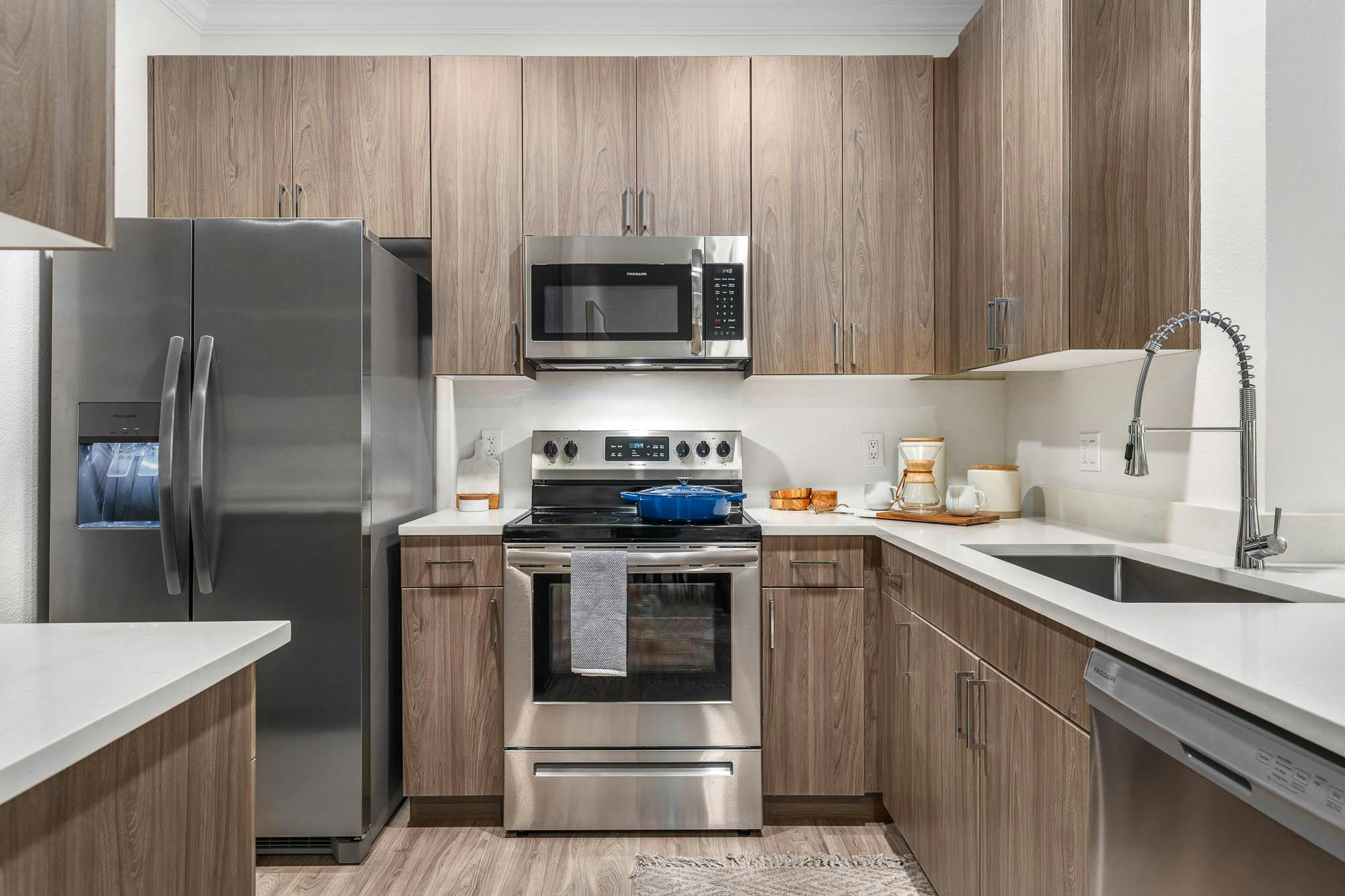 Renovated multifamily apartment kitchen with stainless steel appliances and quartz countertops in Gilbert, AZ