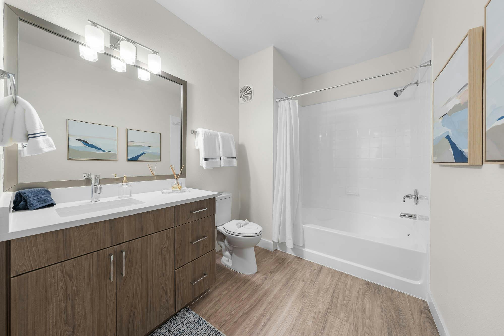 Updated apartment bathroom renovation with modern vanity and bathtub enclosure in Gilbert, AZ