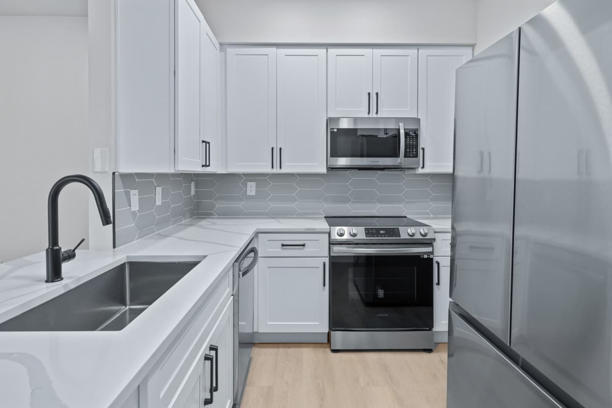 Renovated apartment kitchen with white shaker cabinets and stainless steel appliances in Phoenix, AZ