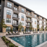 Multifamily property exterior with pool and outdoor amenity area