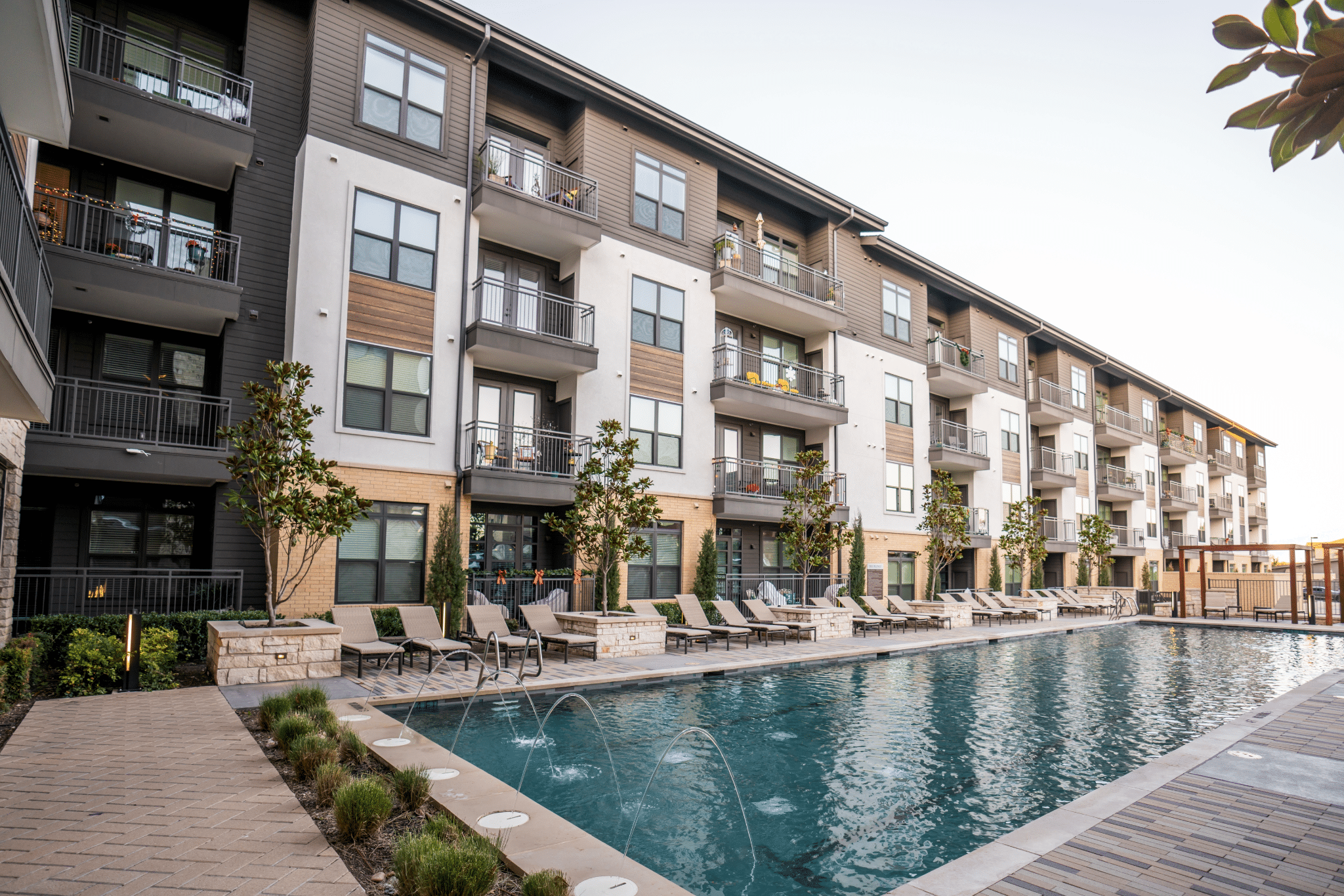 Multifamily property exterior with pool and outdoor amenity area
