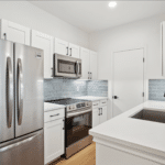 Renovated multifamily apartment kitchen with updated cabinets, countertops, fixtures, and appliances