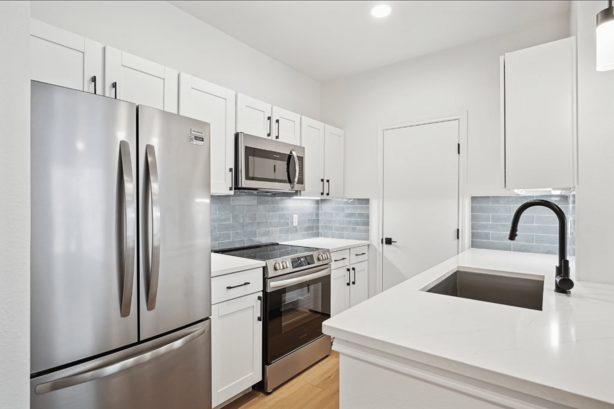 Renovated multifamily apartment kitchen with updated cabinets, countertops, fixtures, and appliances